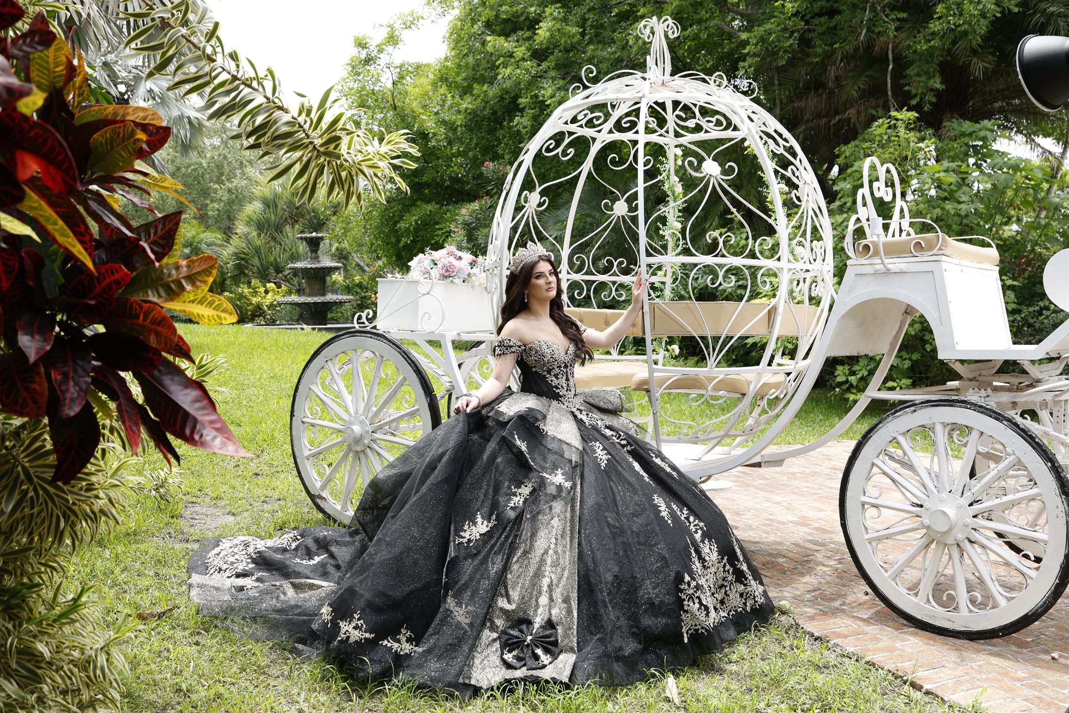 Isabella beside a Cinderella carriage in the garden