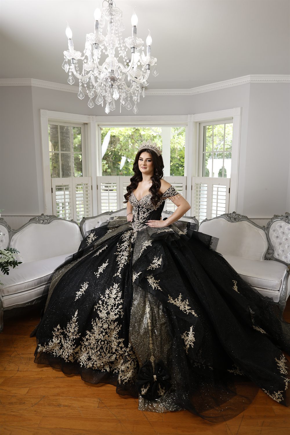 Isabella on a white sofa beneath a chandelier