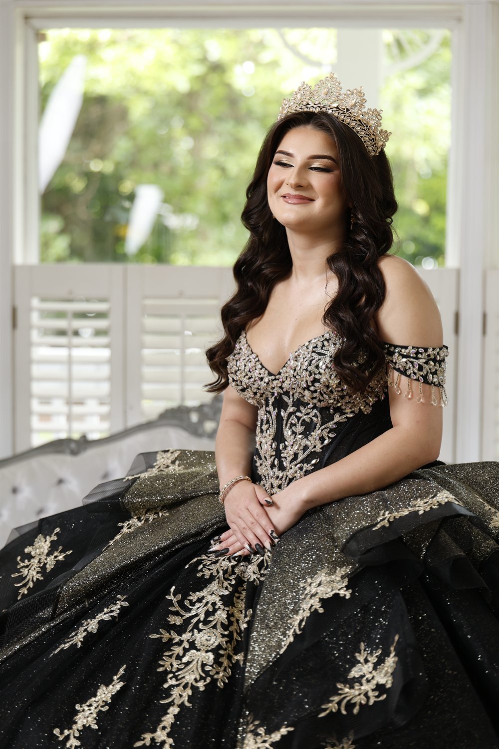 Isabella by a sunlit window in her ballgown